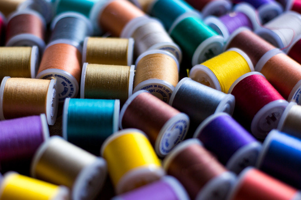 threads for embroidery and sewing in different colors background soft focus - Fotoğraf, Görsel