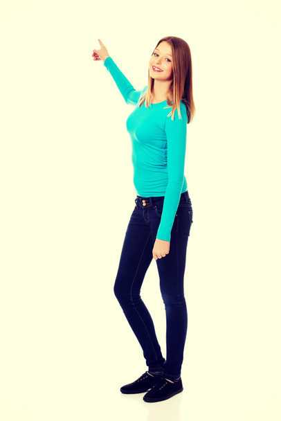 Young woman pointing up  - Foto, imagen