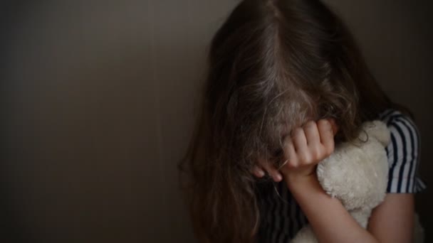 Mała dziewczynka płacze w rogu. pojęcie przemocy w rodzinie. - Materiał filmowy, wideo