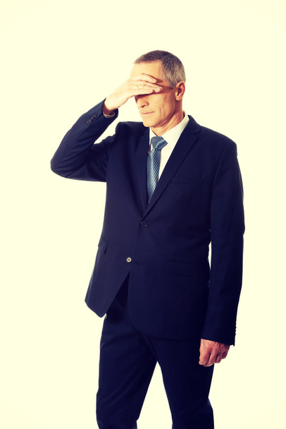 Stressed businessman covering his face - Foto, imagen