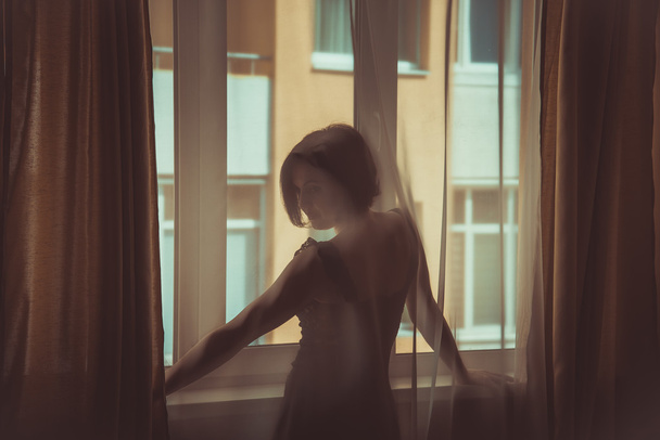A girl looks out the window - Zdjęcie, obraz