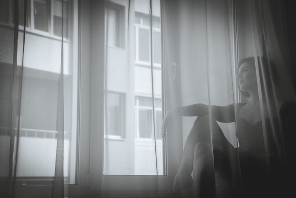 A girl looks out the window - Valokuva, kuva