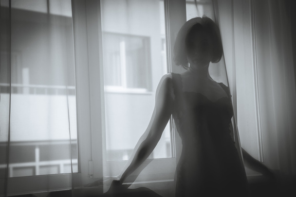 A girl looks out the window - Foto, immagini