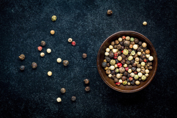 grãos de pimenta em uma tigela de madeira
  - Foto, Imagem