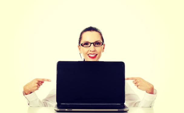 Woman with laptop points to the screen. - Foto, Imagen