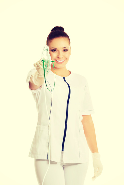 Женщина-врач держит кислородную маску
 - Фото, изображение