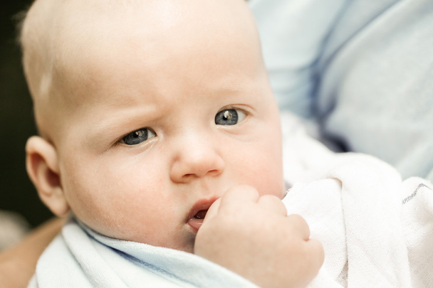 Portrait d'un bébé garçon aux yeux bleus unique dans la douleur de dentition
 - Photo, image