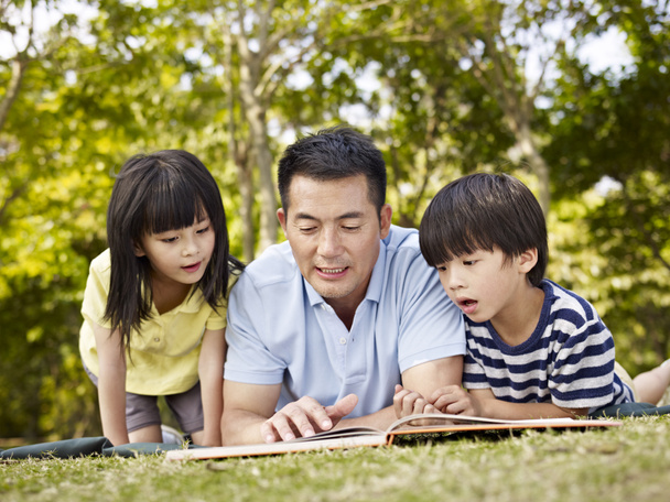 asian father and children reading book together - Photo, Image