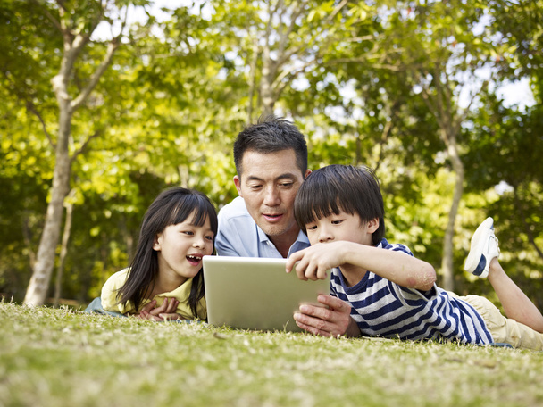 ázsiai apa és a gyerekek tabletta számítógép szabadban - Fotó, kép