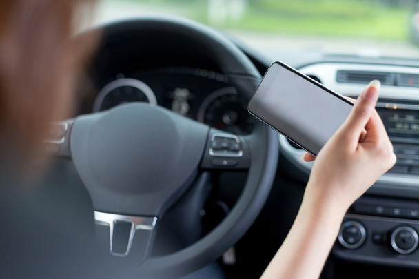 woman using mobile phone and driving car - Foto, Bild