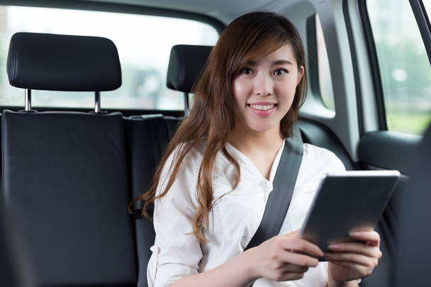 asian woman using digital tablet in car - Foto, Imagen
