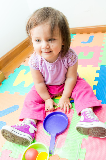 Adorable baby girl playing on floor mats - Foto, Bild