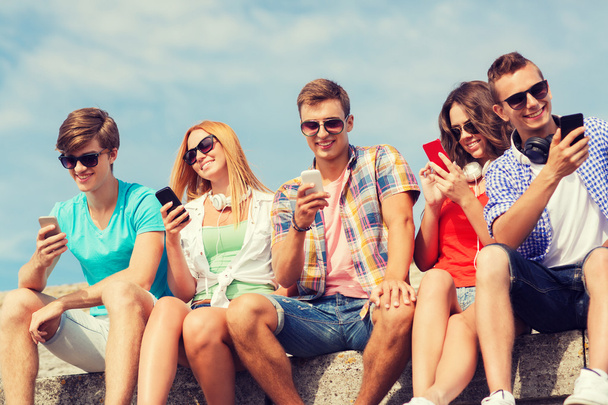 group of smiling friends with smartphones outdoors - Foto, Imagen