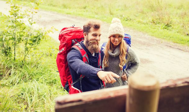 smiling couple with backpacks hiking - Foto, afbeelding