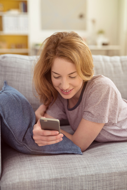 Smiling young woman checking text messages - Foto, immagini