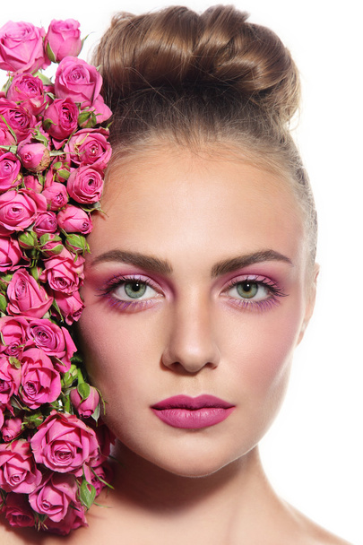 woman with hair bun and pink roses - Zdjęcie, obraz