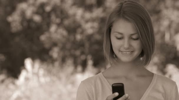 usmívající se krásná mladá žena s telefonem - Záběry, video
