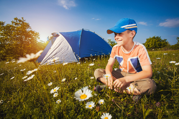  Kid with a tent on a camomile meadow  - Фото, изображение