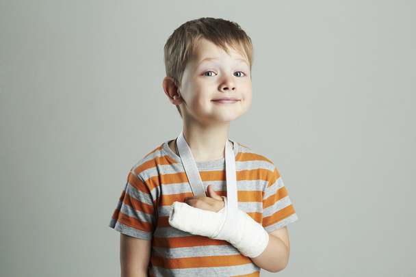 Egy kisfiú gipszben. Egy gyerek törött karral. vicces gyerek baleset után - Fotó, kép