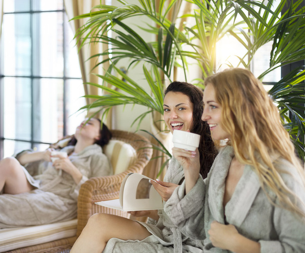 Три молодые женщины пьют чай на курорте
 - Фото, изображение
