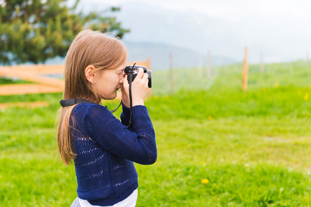 χαριτωμένο μικρό κορίτσι λαμβάνοντας φωτογραφίες με μια φωτογραφική μηχανή - Φωτογραφία, εικόνα