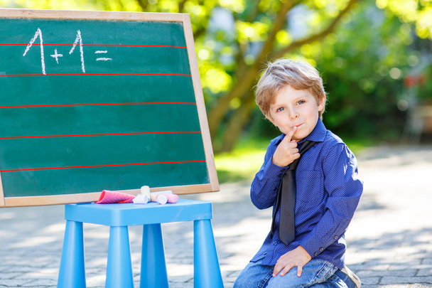 Μικρό αγόρι στο μαυροπίνακα, μαθαίνοντας να γράψετε - Φωτογραφία, εικόνα