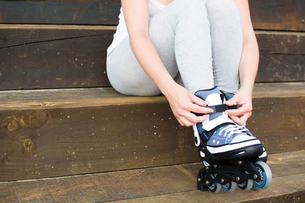 young woman with roller-skates sitting on a staircase - Foto, imagen