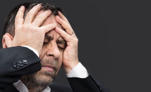  fejfájás. ember kezében zárt arc - Fotó, kép