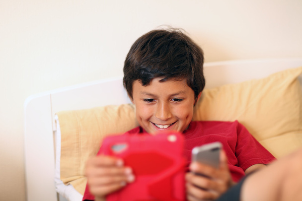 Молодий хлопчик робить селфі фотографії зі смартфоном і планшетом
 - Фото, зображення