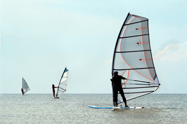 Siluetas de tres windsurfistas
 - Foto, Imagen