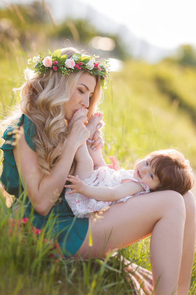 Happy woman with a child resting on the nature - 写真・画像