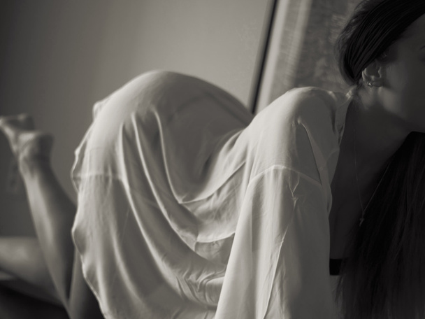 Foto interior de moda de mujer hermosa sexy con cabello oscuro en túnica blanca en la mesa, irreconocible
  - Foto, Imagen