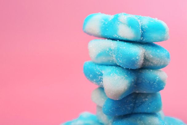 Stack of blue candies on pink background - Фото, изображение