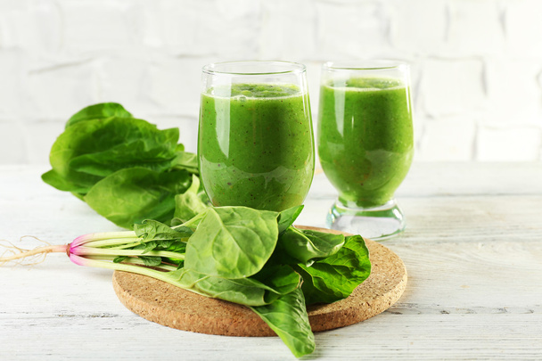 Healthy green smoothie with spinach on wooden table on white wall background - Fotografie, Obrázek