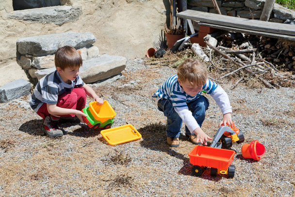 Two boys playing outdoor with toys - Foto, afbeelding