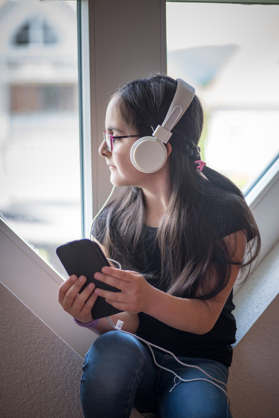 Мила дівчина в окулярах слухає музику
 - Фото, зображення