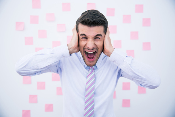 Businessman covering his ears and shouting - Photo, image