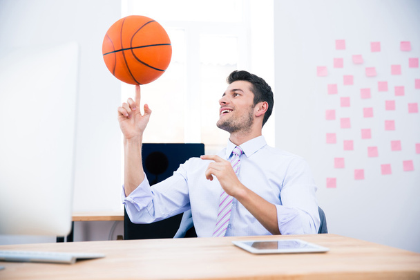 Smiling businessman spining ball in office - Foto, immagini