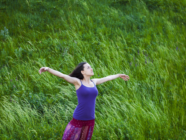 Romantic girl stands in a field in the wind. - Foto, imagen