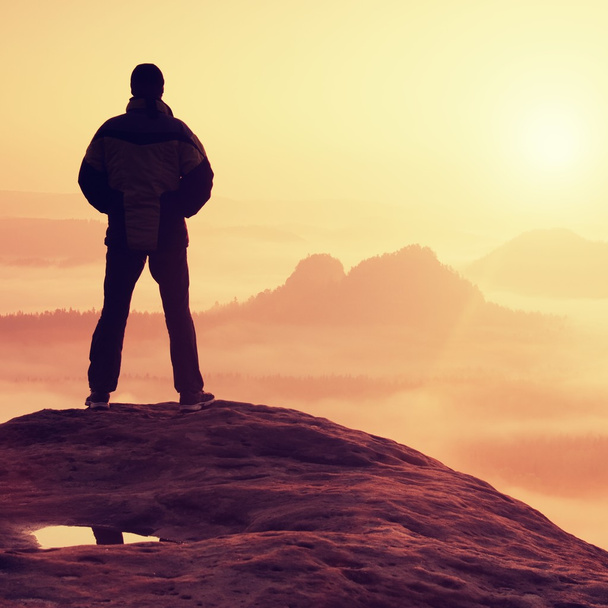 Randonneur seul debout au sommet d'une montagne et profitant du lever du soleil
 - Photo, image