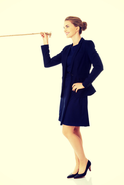 Businesswoman holding rope - Foto, afbeelding