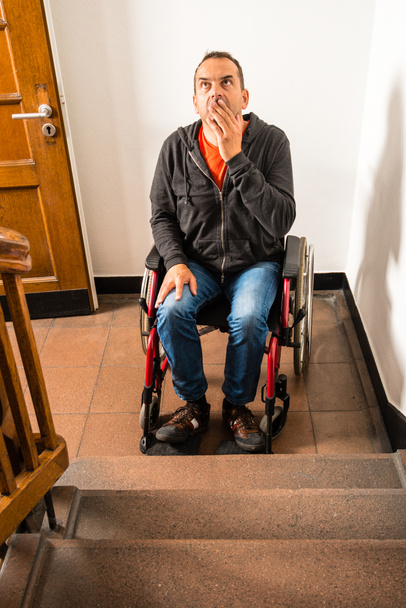 Человек в инвалидной коляске стоит перед лестничным барьером
 - Фото, изображение