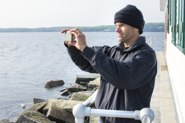 El hombre toma una foto panorámica del teléfono celular en el puerto de Maine
 - Foto, Imagen