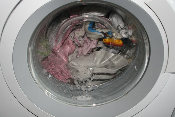 Lavagem de roupa suja em uma máquina de lavar roupa dentro de casa
 - Foto, Imagem