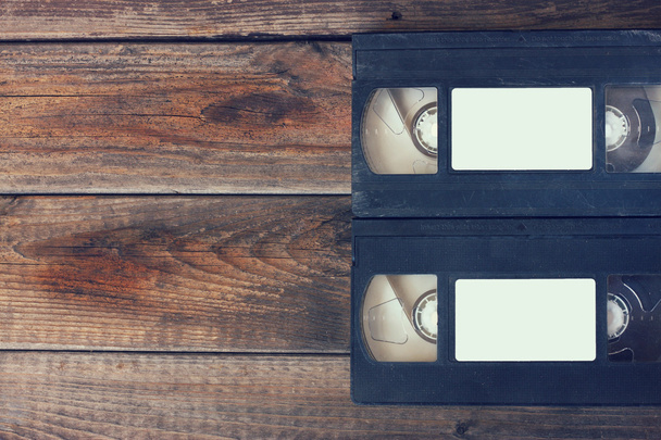 stack of VHS video tape cassette over wooden background. top view photo. retro style image - Фото, изображение