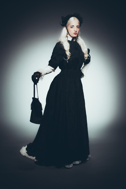 Frau mit Handtasche im schwarzen Kleid - Foto, Bild