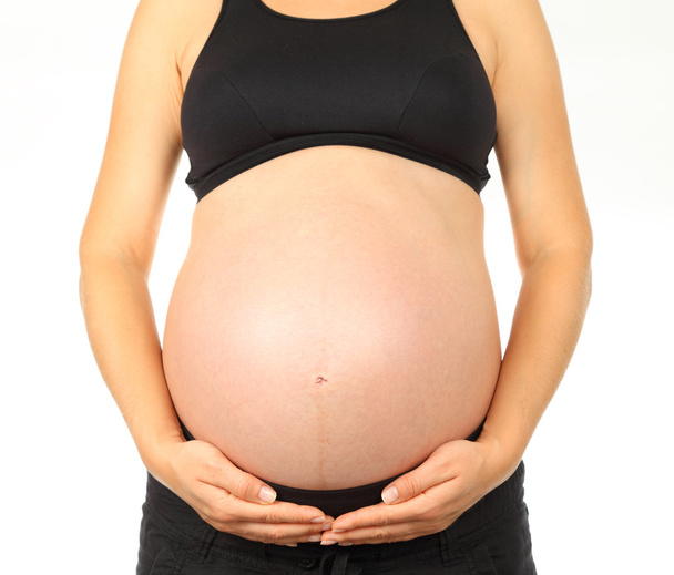 Молода вагітна жінка тримає живіт
 - Фото, зображення
