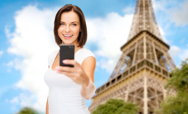 woman taking selfie with smartphone in paris - 写真・画像