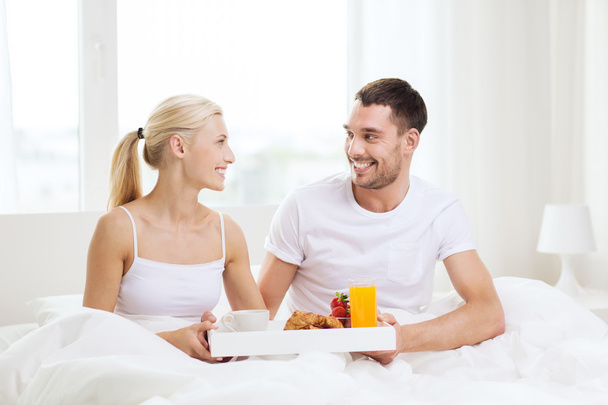 happy couple having breakfast in bed at home - 写真・画像