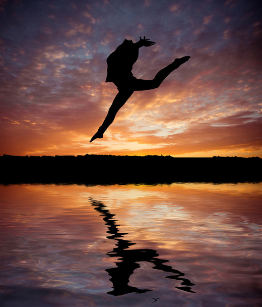 Silhouette jumping  gymnast  at  sunset - Valokuva, kuva